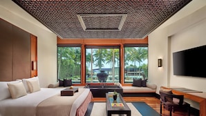 A modern hotel room with a large bed, a sofa, a coffee table, and a TV. - Setai (Miami Beach)
