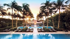 A resort pool with lounge chairs and palm trees. - Setai (Miami Beach)