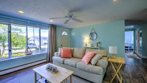 A living room with a sofa, coffee table, and a ceiling fan. - Walk to family friendly beach in West Dennis! (Dennis)