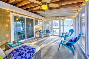 A covered patio area with a ceiling fan, wicker chairs, and a table with a blue patterned tablecloth. - Walk to family friendly beach in West Dennis! (Dennis)
