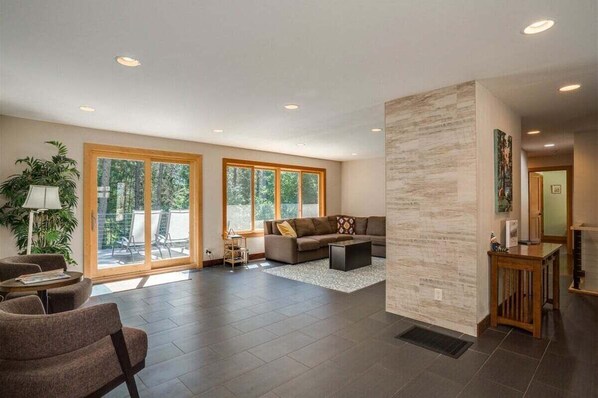 A spacious living area with a sofa, coffee table, and a large window.