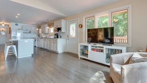 A spacious living area with a kitchen, a dining area, and a seating area with a television.