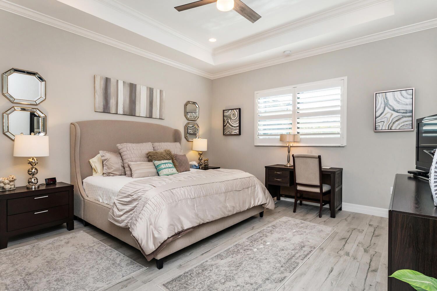 A bedroom with a bed, nightstands, a desk, and a chair.