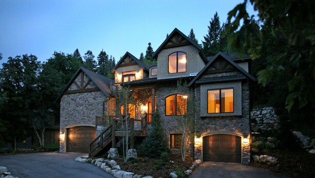 A large, multi-story stone house with a stone facade, multiple windows, and a driveway. - BOULDER RIDGE - 7 BD, HUGE THEATER, POOL TABLE, HOT TUB, SAUNA (Sundance)