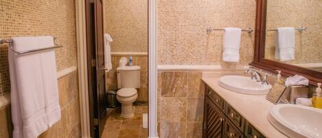 A bathroom with two sinks, a toilet, and a mirror.