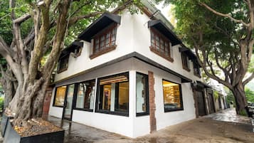Un bâtiment à deux étages, doté de grandes fenêtres et d’une façade blanche.
