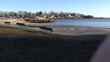 Ranta lähistöllä, aurinkotuoleja, rantapyyhkeitä