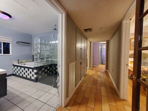 A modern bathroom with a glass shower enclosure, a checkered tile floor, and a hallway leading to a bedroom. - 🌴 Escape in a private pool, jacuzzi, bbq, koi pond, garden, best outdoor area! (Las Vegas)
