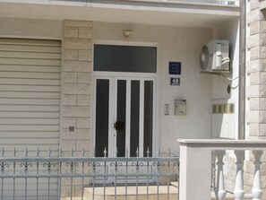 A building entrance with a double door, a mailbox, and a sign indicating the address.