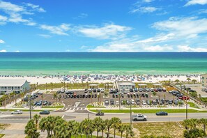 A beach view with a parking lot and a building.