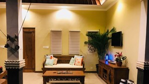 A living room with a sofa, coffee table, and a television. - Welcome to Paradise. Quiet & Tranquil.  Pool & Garden  (Ubud)