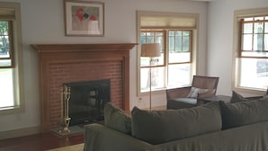 A living room with a fireplace, a sofa, a coffee table, and a rug. - Sag Harbor Village Gem (Sag Harbor)