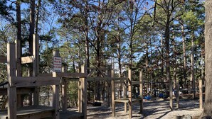 A playground with wooden structures and a sign indicating that minors must be accompanied by an adult. - The Resting Place on Pine Cove at Mountain Harbor (Mt Ida)