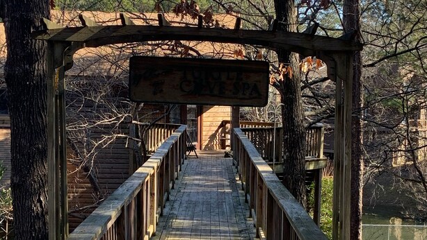 A wooden bridge with a caution sign warning of slipperiness when wet. - The Resting Place on Pine Cove at Mountain Harbor (Mt Ida)
