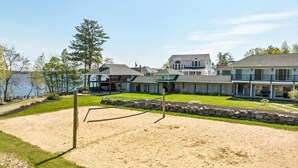 Ein Wohngebiet mit Sandstrand, einem Pavillon und Häusern mit großen Fenstern und Balkonen.