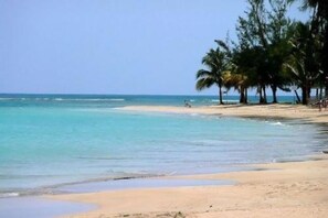 Na praia, espreguiçadeiras, toalhas de praia 