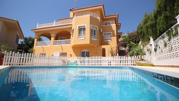 A two-story building with a swimming pool in front.