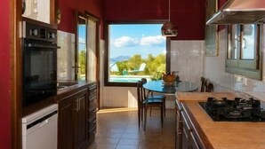 Eine Küche mit Blick auf einen Pool, einem Essbereich und einem eingebauten Backofen.