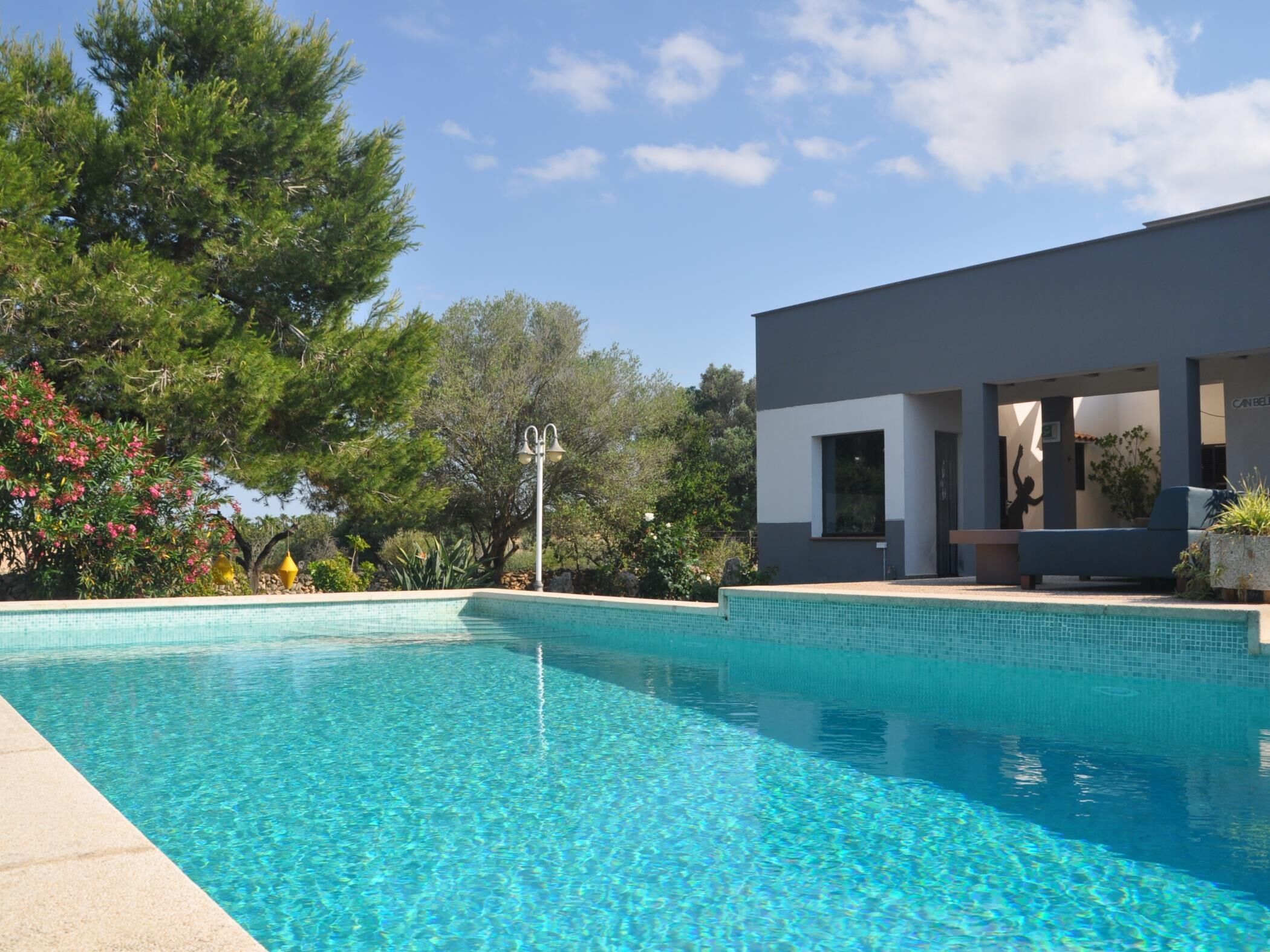 Une piscine d’un bleu éclatant, avec un bâtiment moderne en arrière-plan.