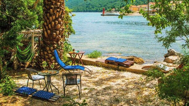 Un cadre paisible au bord du lac, avec un hamac, des chaises longues et une table où l’on peut déguster un verre de vin.