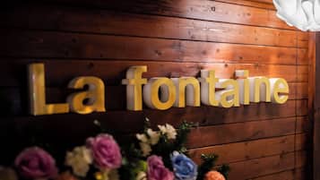 A wooden wall with the words "La fontaine" in gold letters.