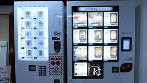 Een automaat met verschillende etenswaren en een digitaal scherm.