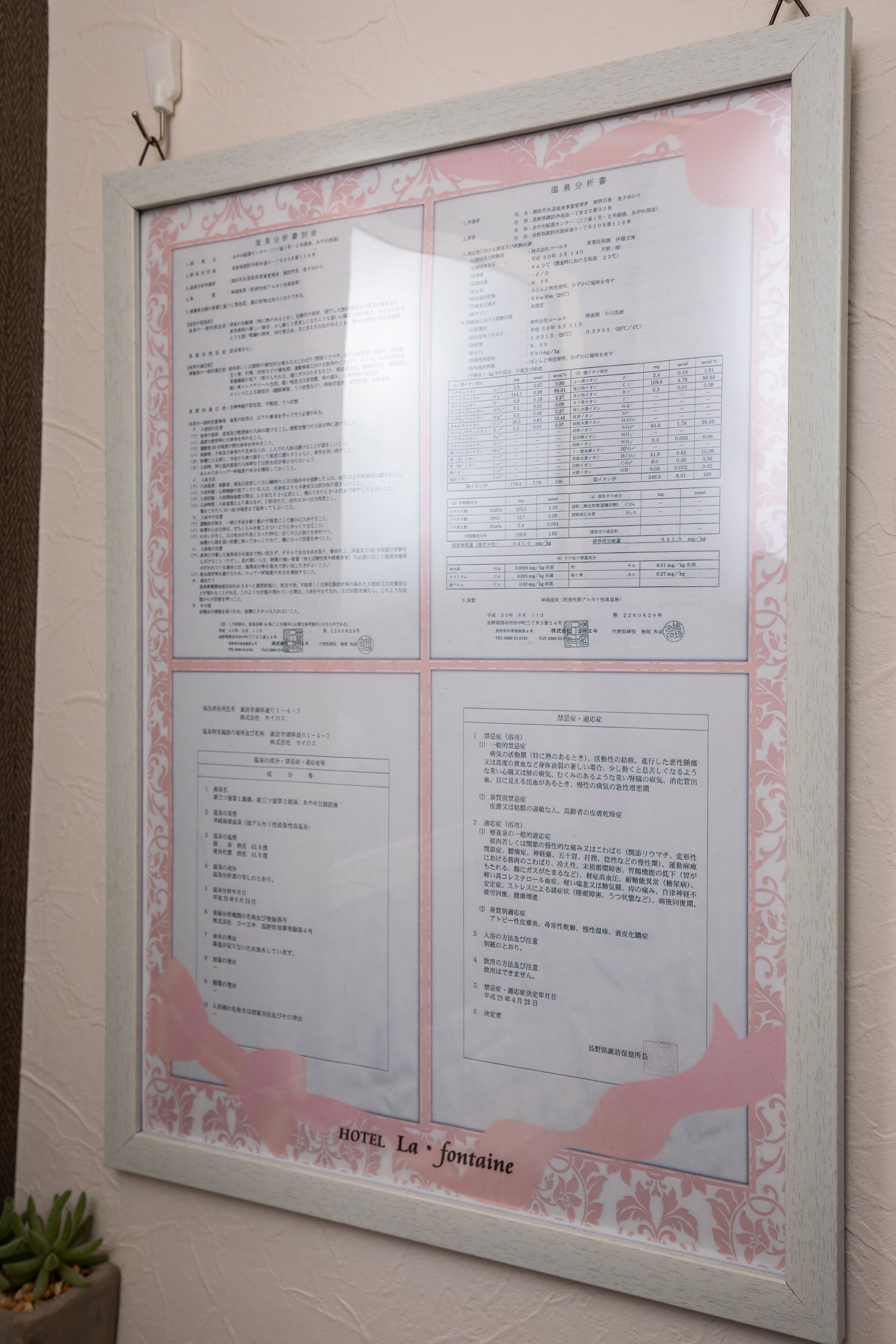 A framed menu board with text and tables, likely detailing hotel services and room information.