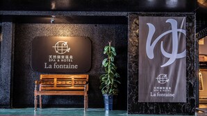 Een bord voor een spa en hotel met de naam 'La fontaine' in zowel Engels als Chinees.
