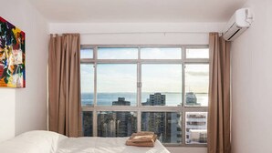 Une chambre d’hôtel avec une grande fenêtre, un lit et un appareil de climatisation.