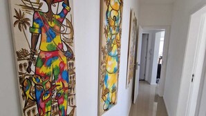Un couloir orné de trois grandes peintures aux couleurs vives.