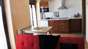 Una cocina compacta con armarios de madera, horno empotrado y campana extractora de acero inoxidable.
