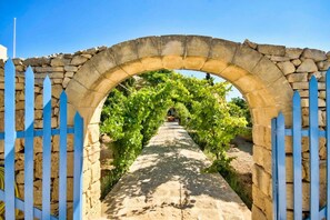 An arched stone gateway leading to a vineyard pathway. - Luxurious 18th C. Farmhouse with Gardens & Pool (Kerċem)