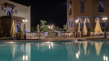 Una piscina al aire libre de temporada, sombrillas