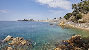 Un pueblo costero con aguas cristalinas, costas rocosas y edificios a lo largo de la playa.