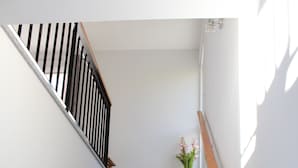 A staircase with granite steps, a wooden handrail, and a small potted plant at the top. - Peaceful Escape Between Ocean and Mountains - Conceição House (Lombo Do Doutor)