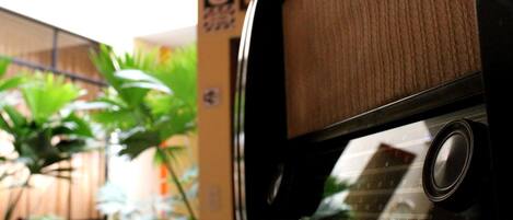 A close-up of a vehicle's side window with a textured surface and a circular object, possibly a speaker, in the center.
