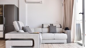A modern living room with a sofa, a coffee table, and a built-in air conditioning unit.