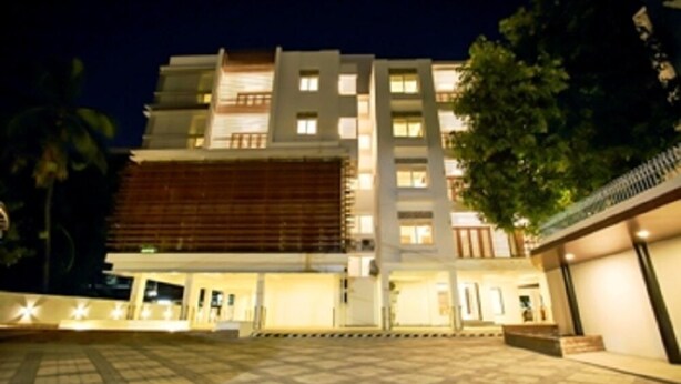 Um hotel com vários andares e design arquitetônico moderno, com uma entrada notável e área externa bem iluminada.