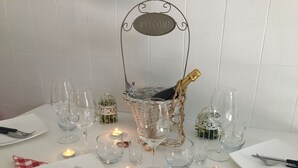A table set for a formal dinner with wine glasses, cutlery, and a bottle of champagne. - The moon and the bonfire IT009024C2SF9H64V7 (Ceriale)