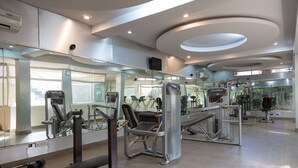 Una palestra moderna con diverse attrezzature per esercizi, ampie specchi e un ambiente pulito e ben illuminato.