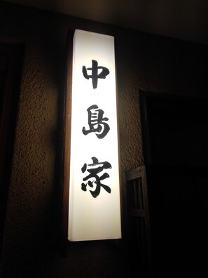 A vertical sign with Chinese characters on a wall.