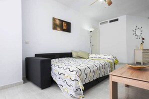 Un dormitorio moderno con cama, mesita de noche y lámpara de pie.