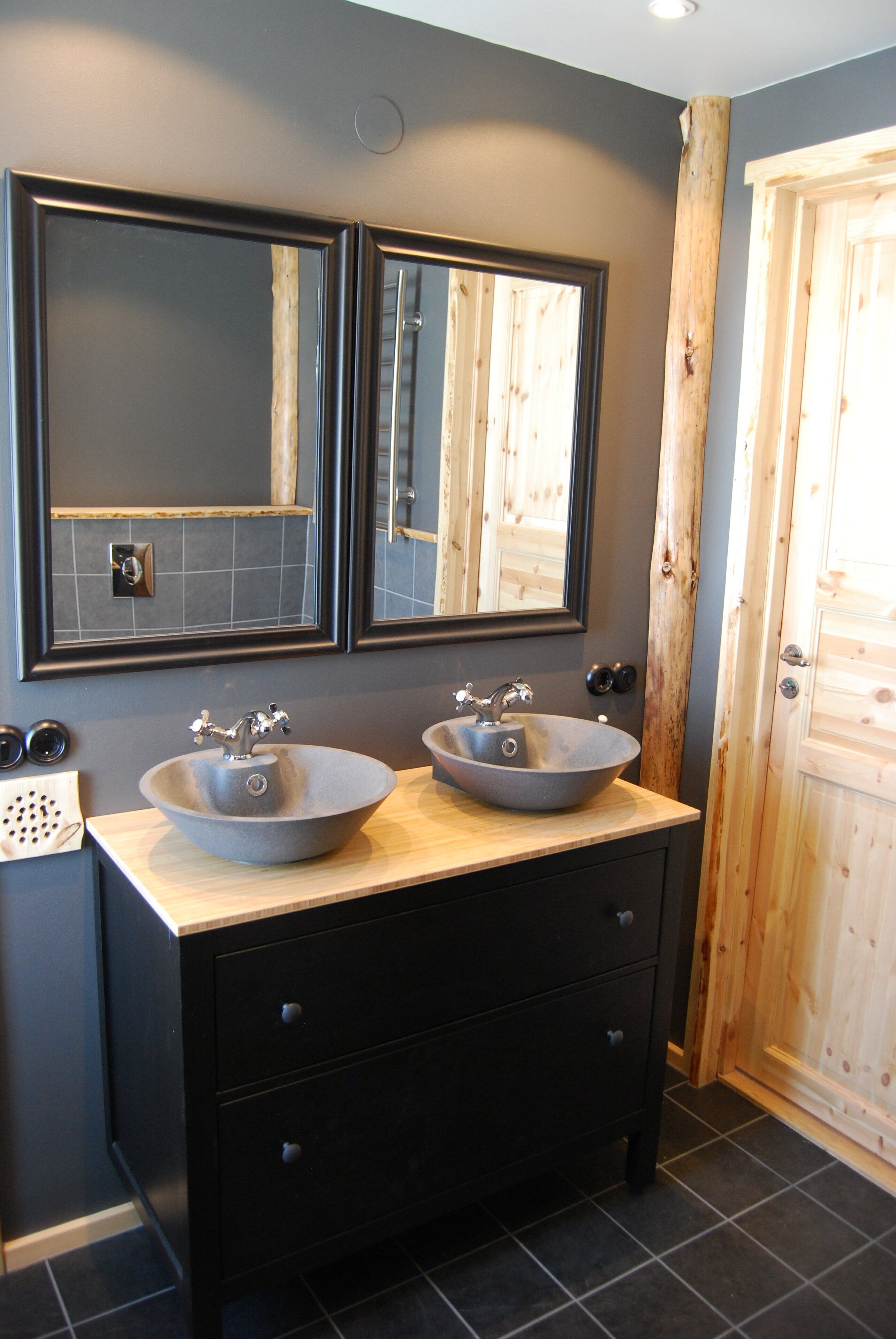 A bathroom with two sinks, a mirror, and a wooden door.