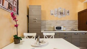 Une cuisine moderne avec des meubles blancs, un four à micro-ondes et une table à manger avec des chaises.