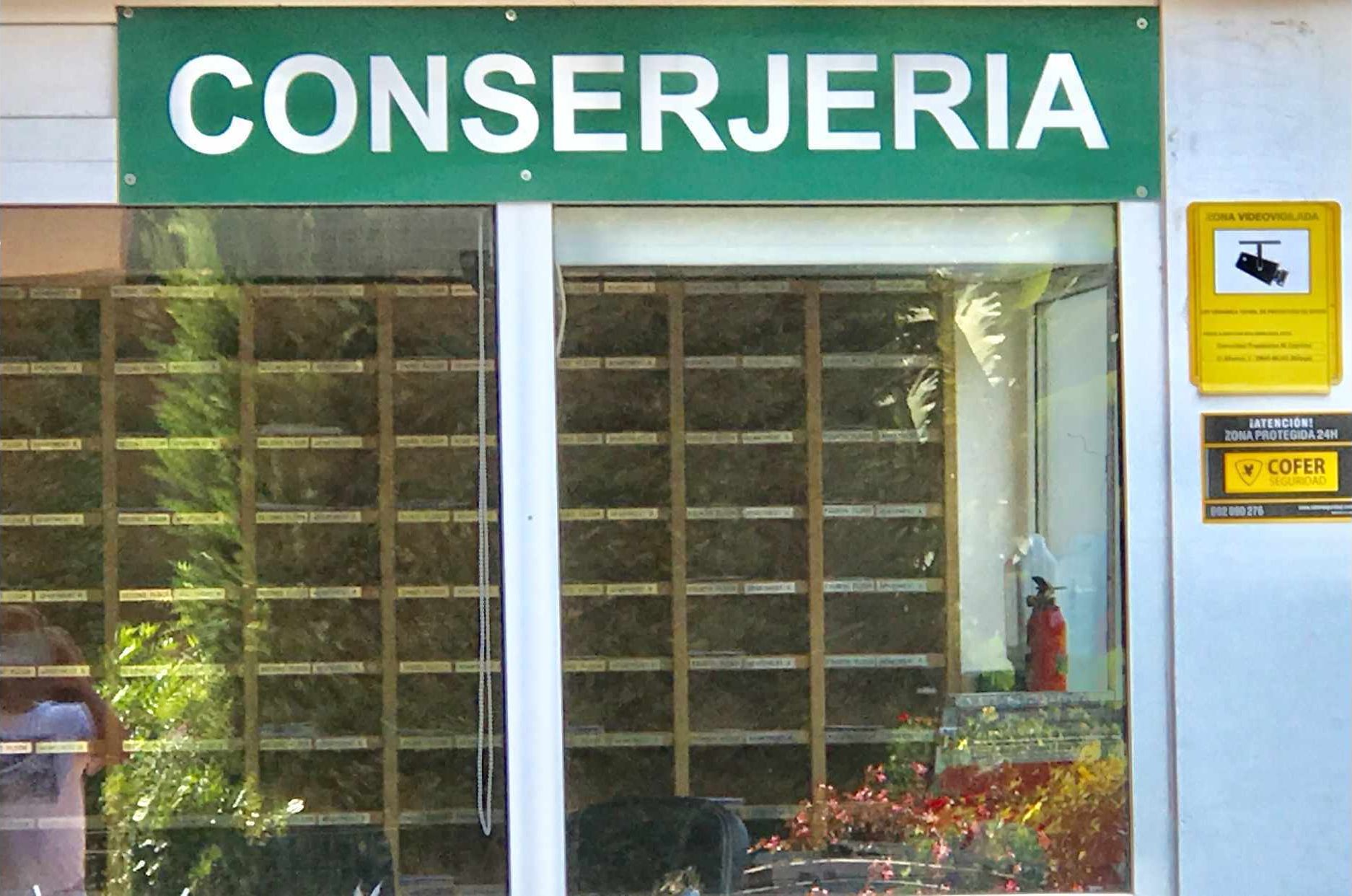 A storefront with a green sign reading "CONSERJERIA".