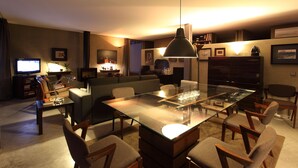 A modern living room with a glass-top coffee table, comfortable seating, and a television.