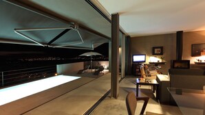 A modern living room with a large window, a flat-screen TV, and a fireplace.
