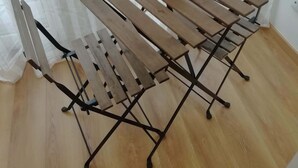A wooden folding table with a metal frame, positioned in front of a window with sheer curtains. - Apartment in the Historic Center of the city, with balcony, air conditioning (Porto)
