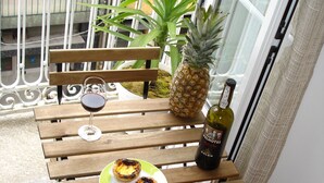 A wooden bench with a plate of food and a bottle of wine. - Apartment in the Historic Center of the city, with balcony, air conditioning (Porto)