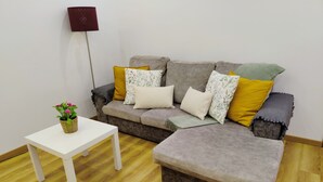 A living room with a grey sofa, a white coffee table, and a small potted plant. - Apartment in the Historic Center of the city, with balcony, air conditioning (Porto)